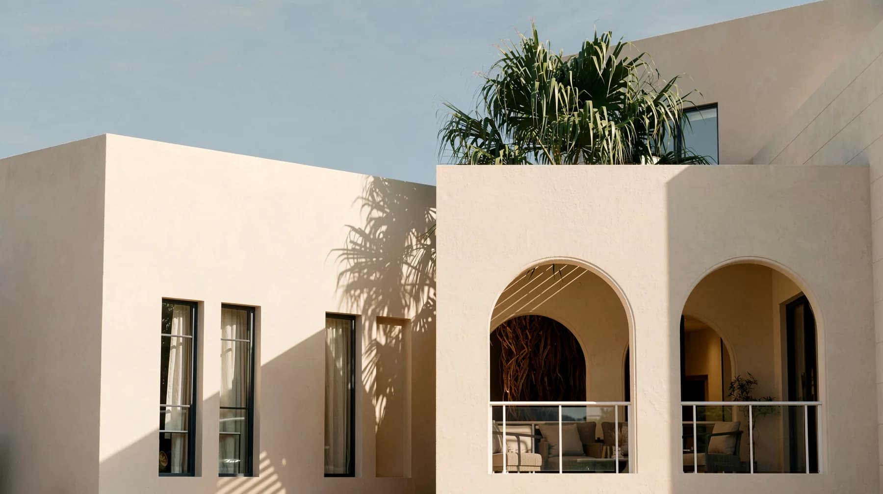 Courtyard Villa by VADO, an arched loggia in warm evening light